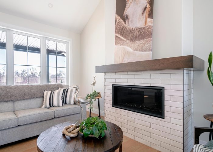 A gas stove, surrounded by tile with a wooden mantle.