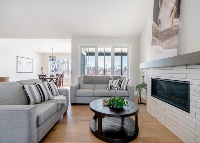 A living room with a gas fireplace and vaulted ceiling.