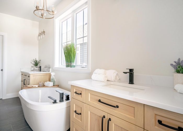 An ensuite bathroom with two wooden vanities and a soaker tub.