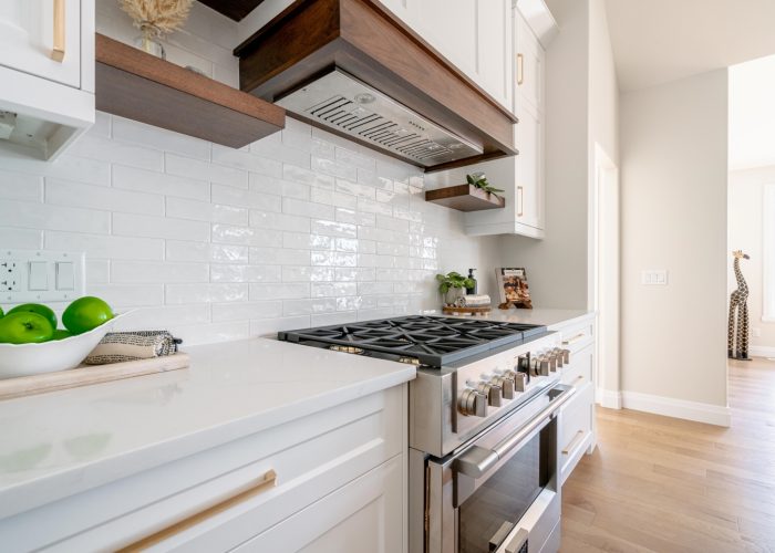 A custom white and stained wood kitchen island, centered on a large range.