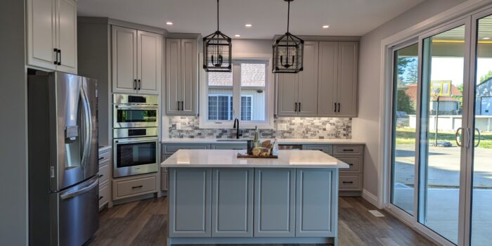A grey cabinetry kitchen with a large sliding door.