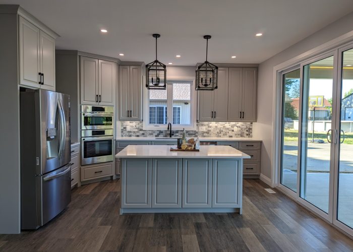 A grey cabinetry kitchen with a large sliding door.