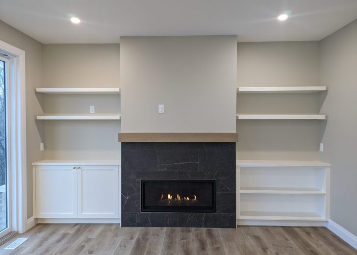 A gas fireplace with wooden mantle and built-in cabinetry on either side.